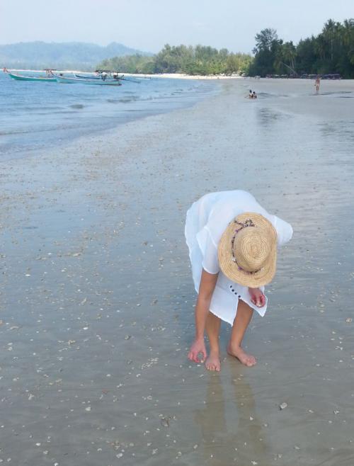 Frau mit weißem Kleid am Strand