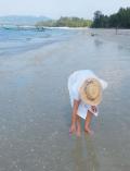 Frau mit weißem Kleid am Strand